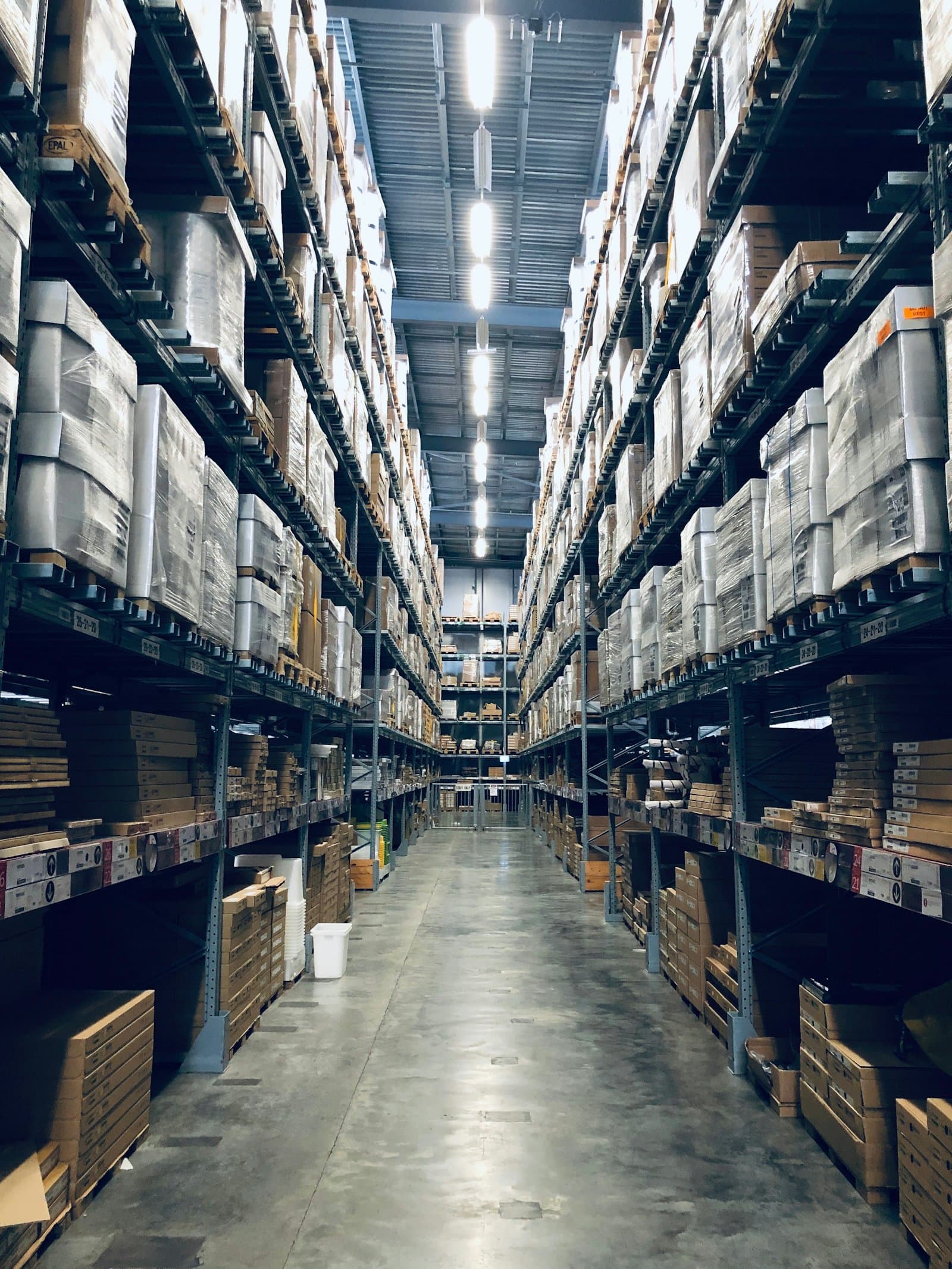Interior de una bodega de distribución con estantería de estibas